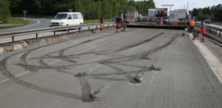 Verwirrte Frau fährt in der Baustelle in frischen Beton   