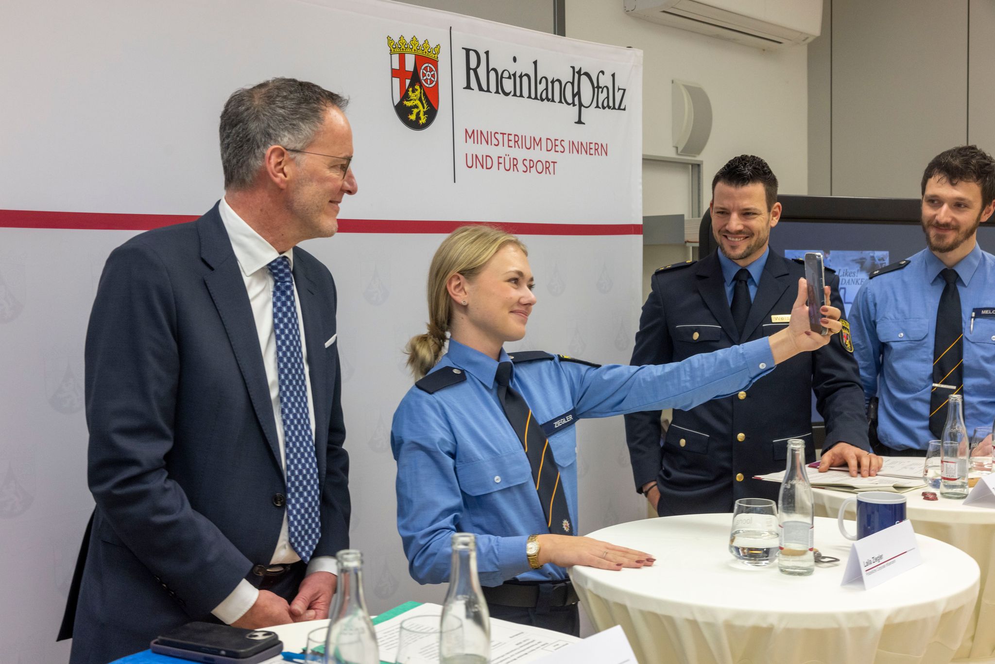 Influencerin Laila Ziegler in Uniform dreht auf der Pressekonferenz kurzerhand ein Video mit Innenminister Michael Ebling (links). 