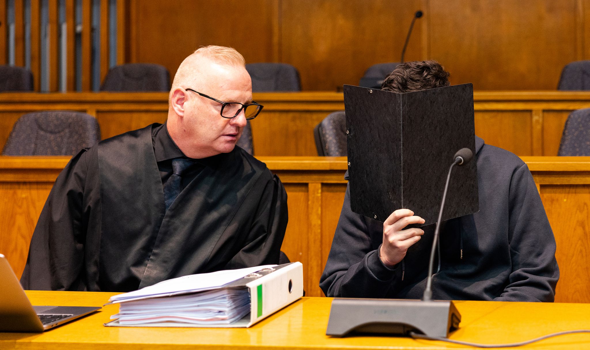 Der wegen Mordes angeklagte junge Mann sitzt neben seinem Verteidiger Michael Rehberger im Landgericht Saarbrücken.