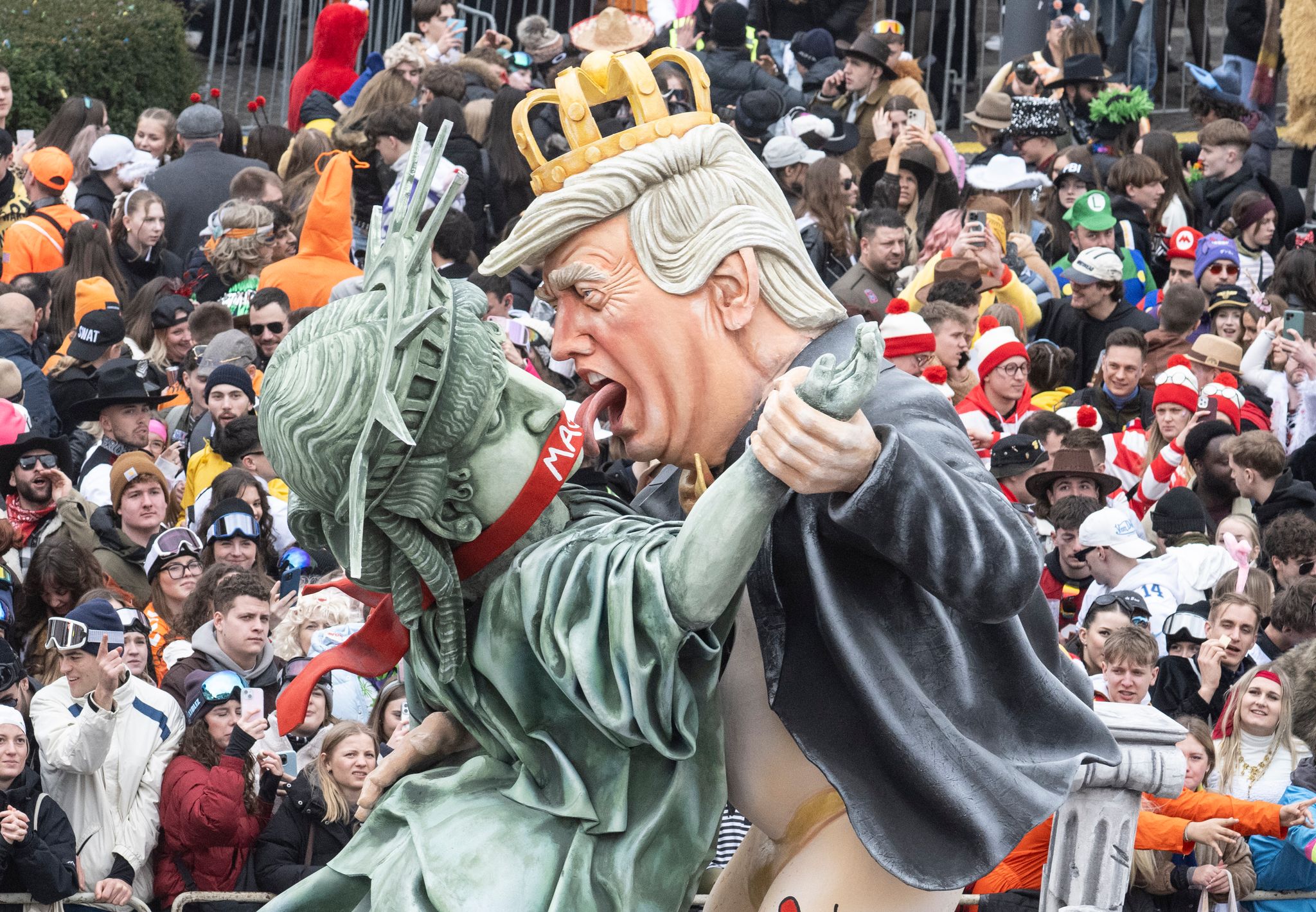 US-Präsident Donald Trump erdrückt auf einem Motivwagen die Freiheitsstatue.