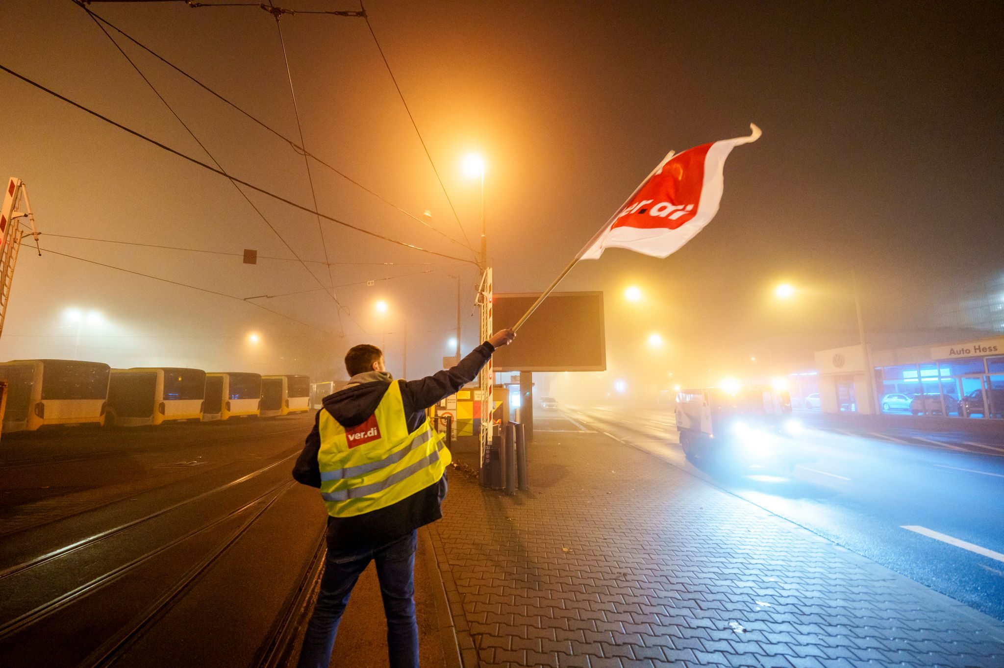 Ein Streikender schwenkt in der Zufahrt zum Straßenbahndepot der Mainzer Mobilität (MVG) die Flagge der Gewerkschaft Verdi. 