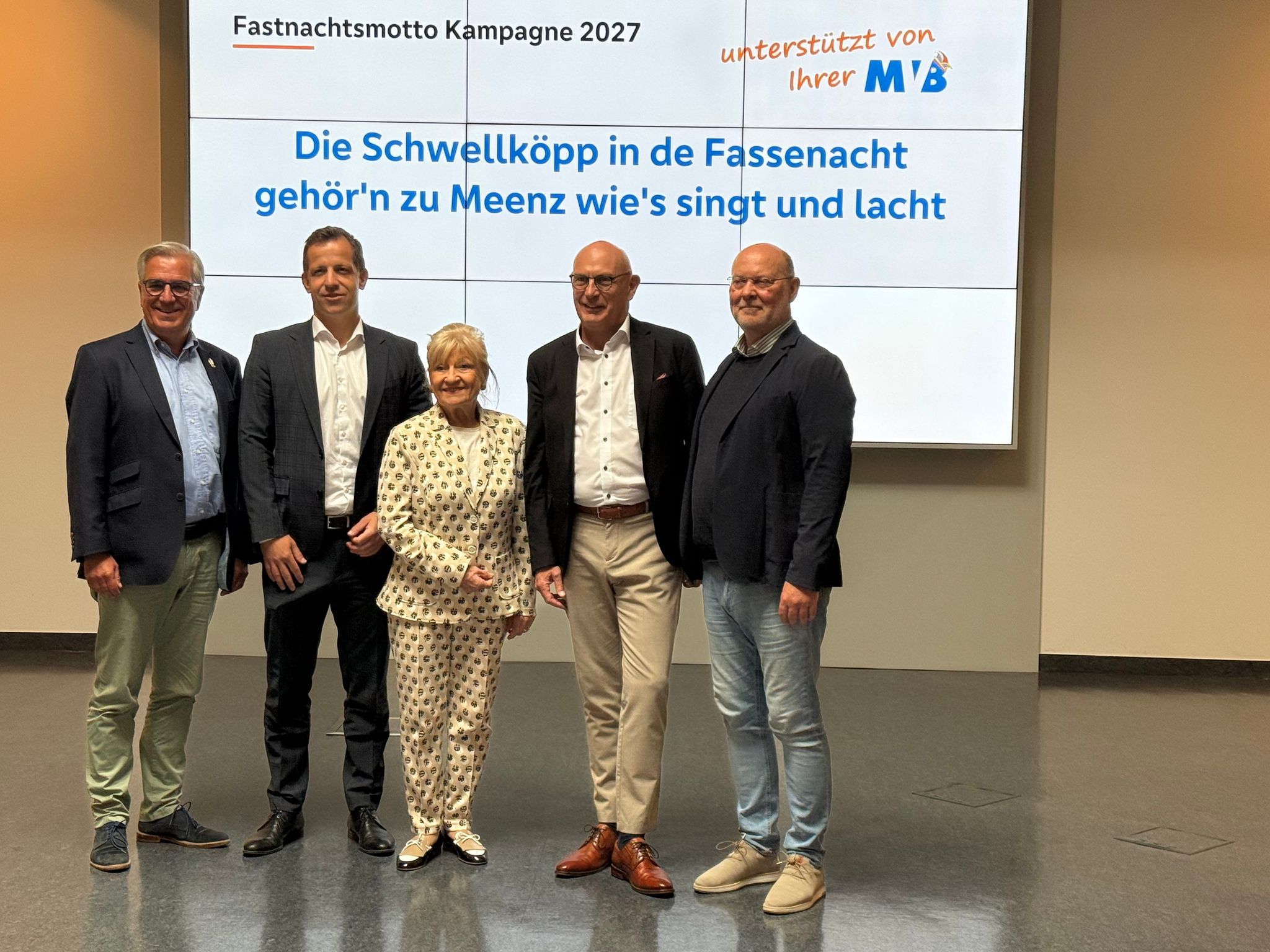 Der Präsident des Mainzer Carneval-Vereins (MCV, l-r), Hannsgeorg Schönig, der Mainzer Oberbürgermeister Nino Haase, die Sängerin und Mainzer Ehrenbürgerin Margit Sponheimer, Uwe Abel von der Volksbank Darmstadt Mainz sowie MCV-Pressesprecher Michael Bonewitz stehen vor dem Motto für die Mainzer Fastnachts-Kampagne.