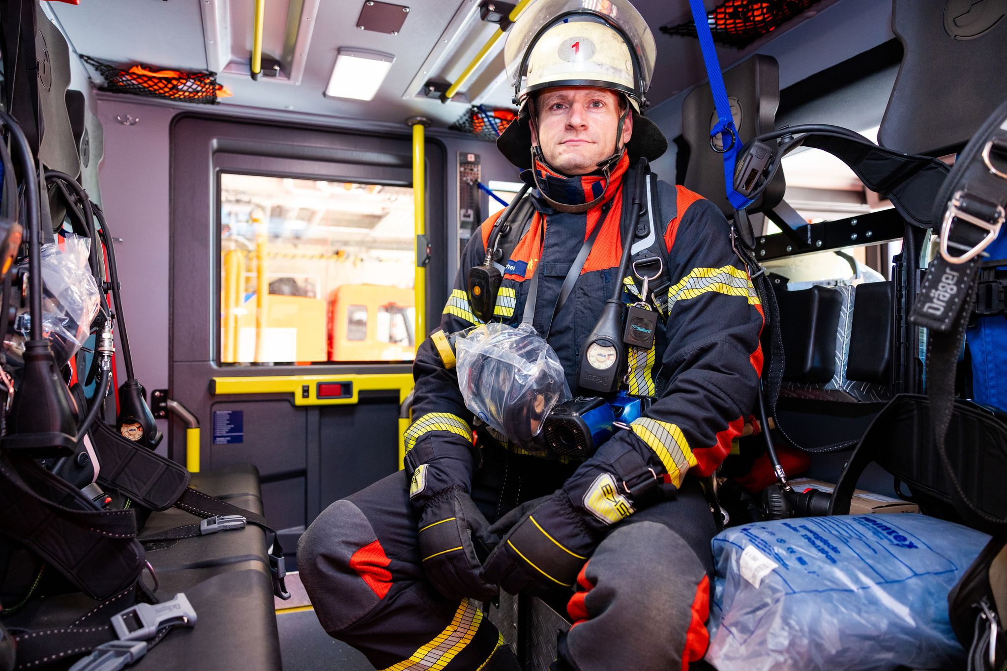 Voll ausgerüstet und einsatzbereit sitzt Hauptbrandmeister Kevin Michel in einem Löschfahrzeug der Berufsfeuerwehr Saarbrücken.